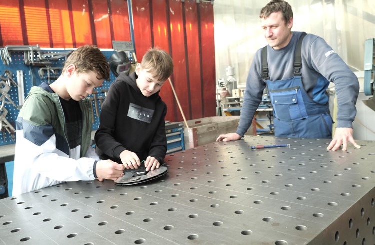 Die beiden Grosswanger Schüler Luca Glanzmann (links) und Iven Stocker fertigen selber eine Chromstahluhr, sie werden angeleitet vom Lehrlingsverantwortlichen Daniel Drago. Foto Hannes Bucher