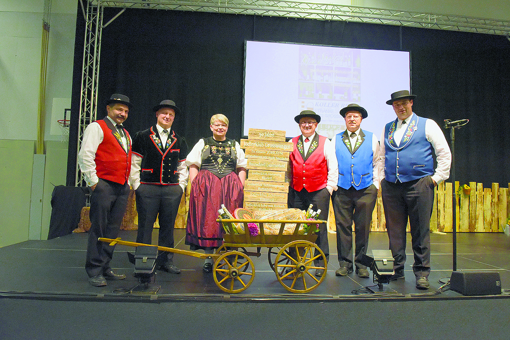 Gaby Zihlmann (Präsidentin JK Grosswangen) wurde von den Vereinspräsidenten mit einem Leiterwagen regionaler Produkte anlässlich des 30-Jahr-Jubiläums beschenkt: (von links) Felix Zurkirchen (Buure Chörli Lozärnerland Grosswangen); Markus Krummenacher (JK Schlossgruess Buttisholz); Gaby Zihlmann (Präsidentin JK Grosswangen); Walter Albisser (JK Heimelig Ruswil); Kurt Ramseier (JK Edelweis Ettiswil) und Ruedi Bachmann (JK Echo vom Rotbach Hellbühl).
