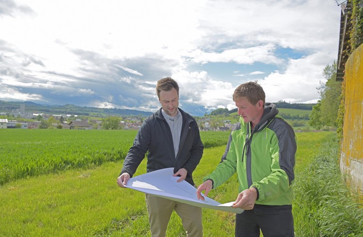 Die beiden Initianten Manuel Hebler (links) und Georg Hodel studieren einen Plan im Gebiet Schweikhüsere, wo das Holzheizkraftwerk realisiert wird. Foto Michael Wyss