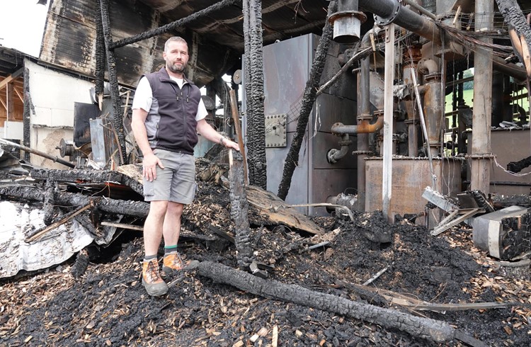 Reto Bucher steht mitten in der Brandruine der zerstörten Holzvergaseranlage. Foto Roland Meyer