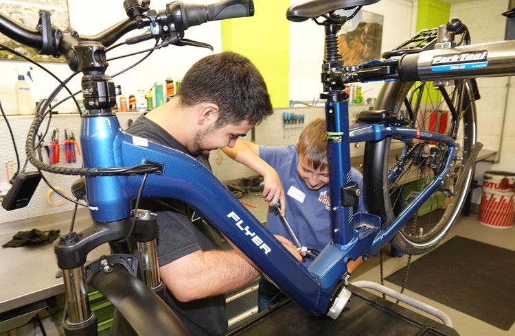 Lukas Wicki (rechts) lernt, wie beim E-Bike der Motor gewechselt wird. Samuel Goncaves von Bikeexpert gibt dazu die genauen Anweisungen. Foto Roland Meyer