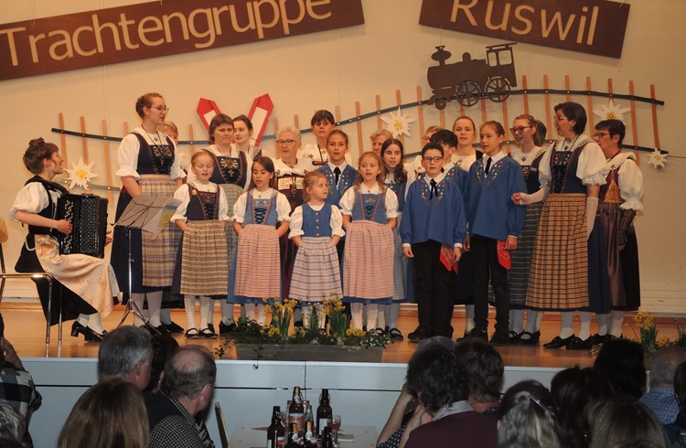 Der Trachtenchor singt mit einer Kindergruppe das Medley «Alpenexpress» aus der Feder von Chorleiterin Ursina Makiol (am Akkordeon). Foto Josef Stirnimann-Maurer