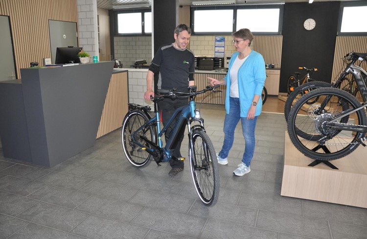 Rolf Schwarzentruber übergibt Kundin Petra Müller nach dem Service das E-Bike. Foto Stefan Schmid