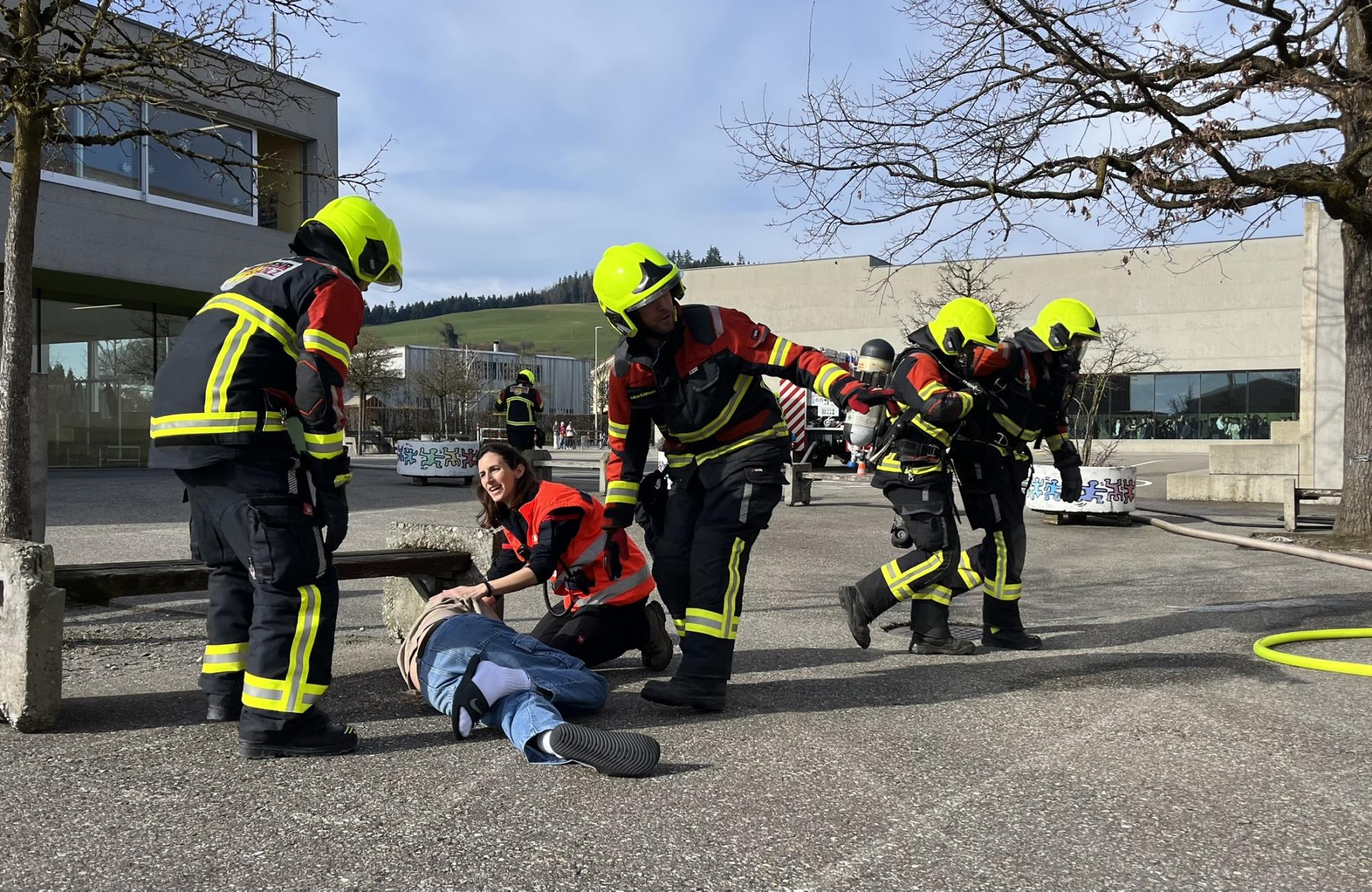 Nach der Bergung des Schülers kümmert sich der Sanitätsdienst um die Erstversorgung. Die mit Atemschutz ausgerüsteten Feuerwehrmänner suchten im Schulhaus nach weiteren Personen. Fotos Debora Moos