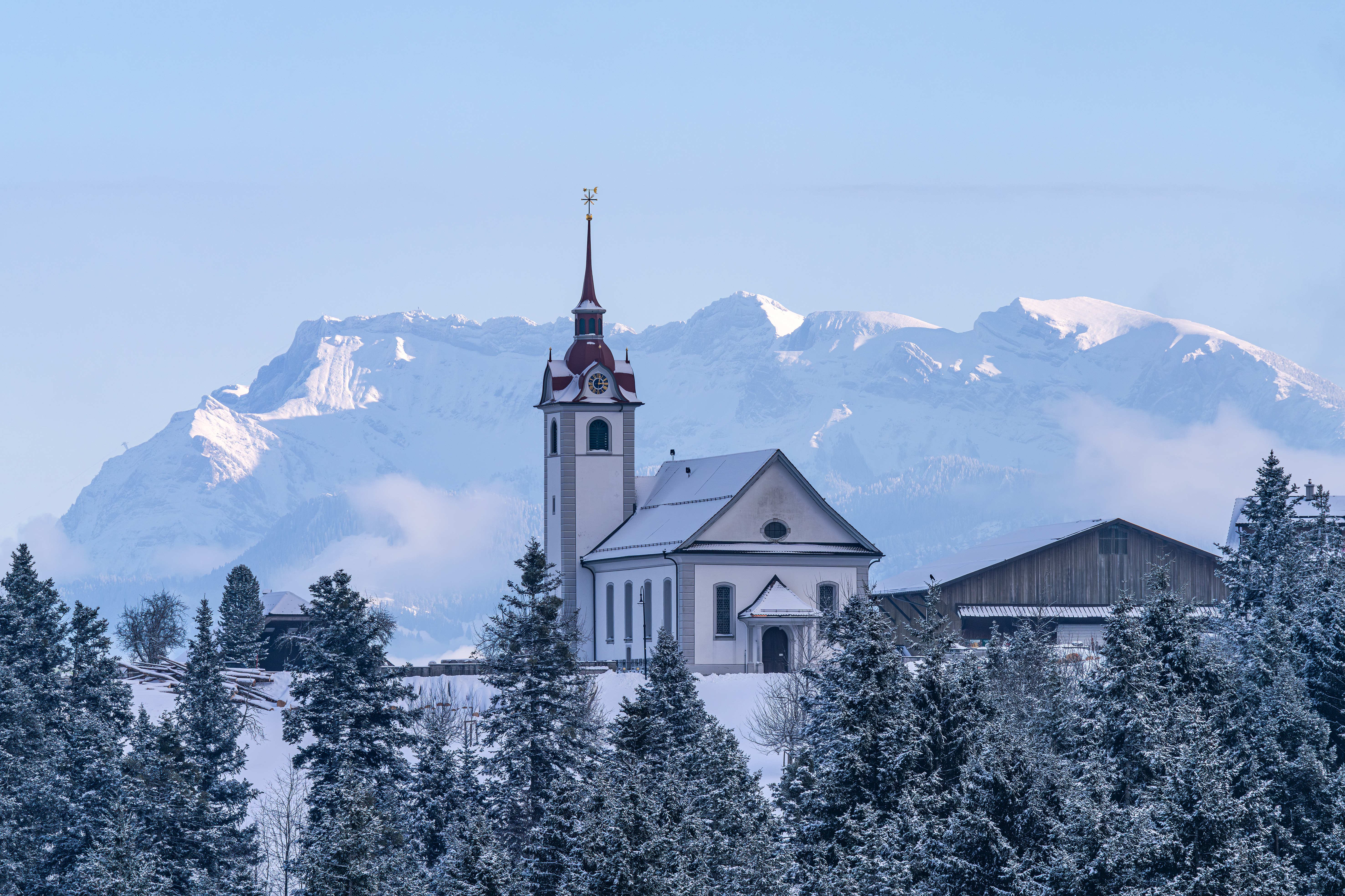 Die Kirche auf dem Menzberg zeigt sich prächtig vor dem verschneiten Pilatus. | Stefan Dubach, Ruswil