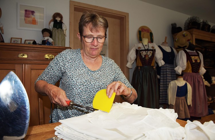 Anna Erni bei der Handarbeit, dem «Röhrlen» für ein «Krägli» mit Hilfe einer Brennschere, in ihrem Geschäft in Hellbühl. Fotos Michael Wyss